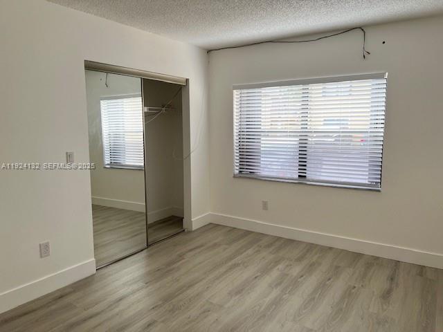 6735 West 26th Drive, Unit 125 Hialeah, FL 33016 - Photo 6 of 9 a view of an empty room with wooden floor and a window