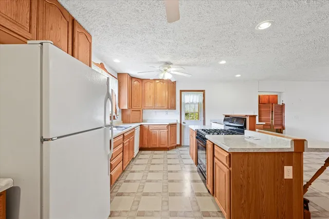 a kitchen with stainless steel appliances granite countertop a refrigerator a stove a sink and a refrigerator