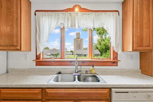 a kitchen sink with a granite countertop window and sink
