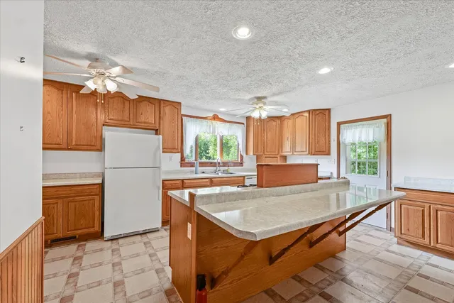 a kitchen with granite countertop a stove a sink dishwasher and a refrigerator with wooden floor