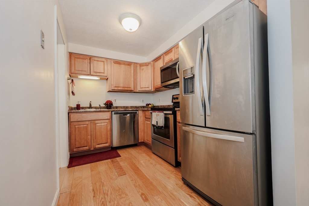 5 East Ridge Road, Unit A Merrimack, NH 03054 - Photo 12 of 19 a kitchen with a refrigerator sink and cabinets