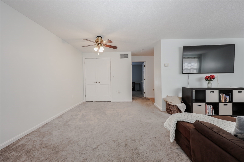 5 East Ridge Road, Unit A Merrimack, NH 03054 - Photo 6 of 19 a living room with furniture and a flat screen tv