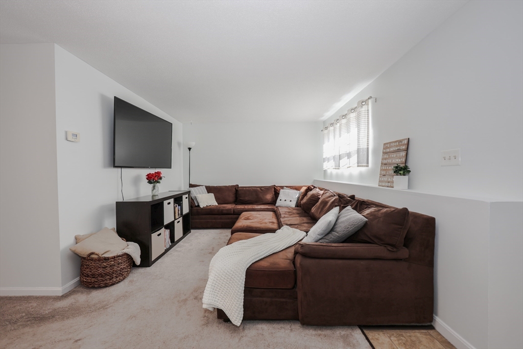 5 East Ridge Road, Unit A Merrimack, NH 03054 - Photo 7 of 19 a living room with furniture a flat screen tv and a window