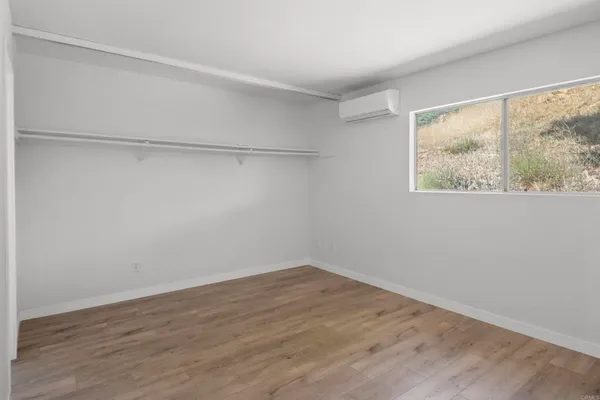 a view of a small space with wooden floor and a window