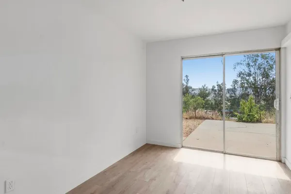 a view of a room with wooden floor and windows