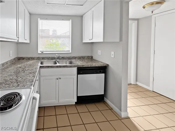 a kitchen with a sink a stove and cabinets