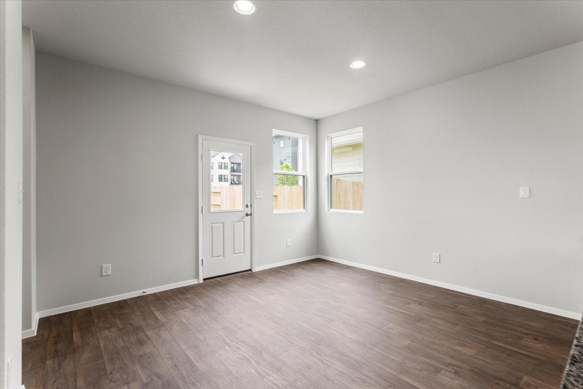 2709 Totley Road Manor, TX 78653 - Photo 15 of 40 an empty room with wooden floor and windows