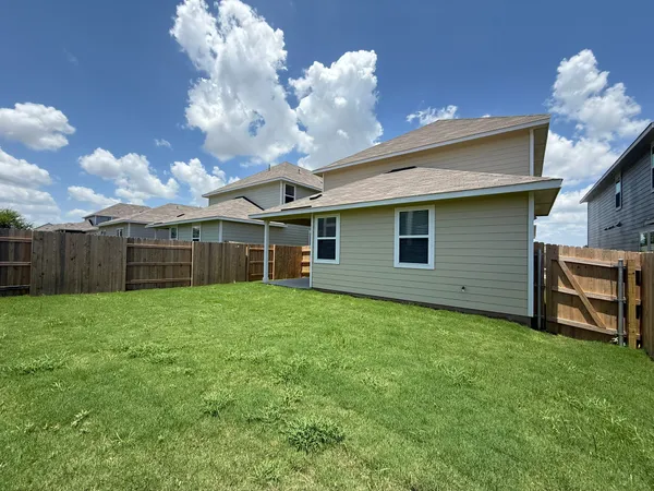 a backyard of a house with table and chairs