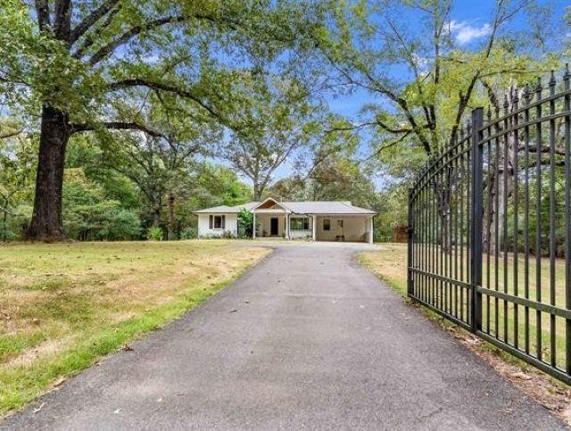 1050 North Reid Hooker Road Eads, TN 38028 - Photo 2 of 4 Long asphalt driveway leading to a white single-story residence