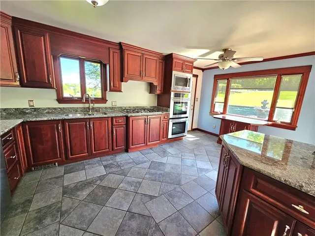 a kitchen with granite countertop a stove sink and cabinets