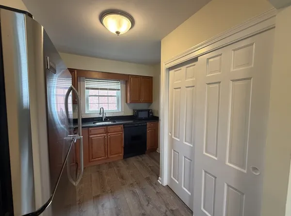 a kitchen with granite countertop a refrigerator and a sink