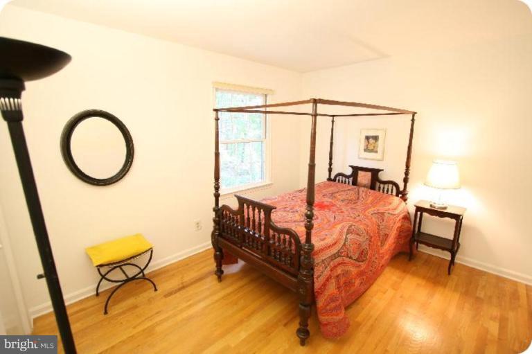 10915 Hunt Club Road Reston, VA 20190 - Photo 19 of 27 a bedroom with a bed window and a table