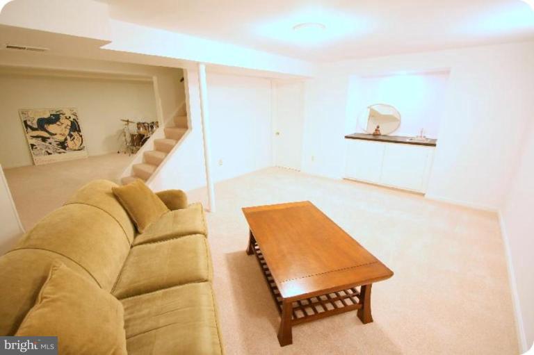 10915 Hunt Club Road Reston, VA 20190 - Photo 21 of 27 a living room with a couch and dresser with wooden floor