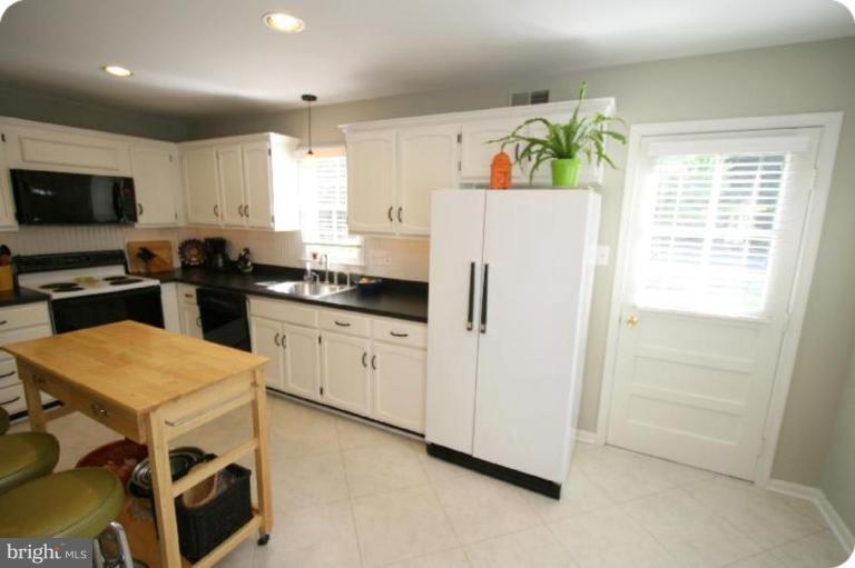 10915 Hunt Club Road Reston, VA 20190 - Photo 7 of 27 a kitchen with a refrigerator a stove and a microwave