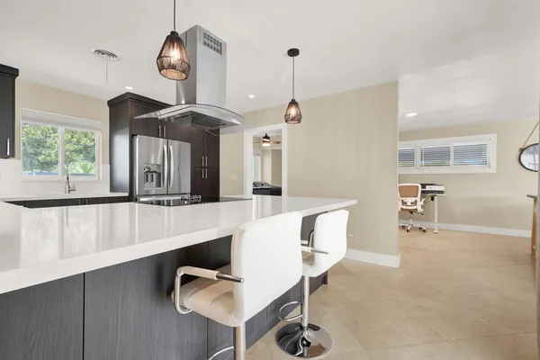 a kitchen with stainless steel appliances granite countertop a sink a refrigerator and a stove