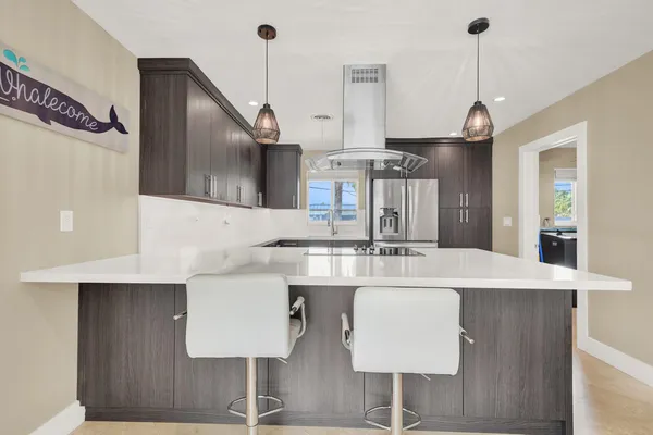 a kitchen with stainless steel appliances a dining table chairs and stove top oven