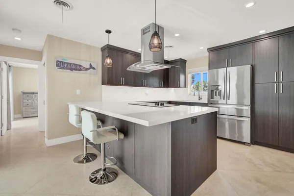 a kitchen with stainless steel appliances kitchen island a sink and a stove