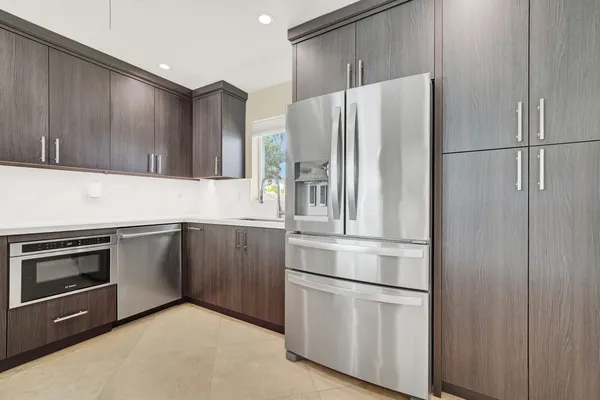 a kitchen with stainless steel appliances granite countertop a refrigerator and a sink