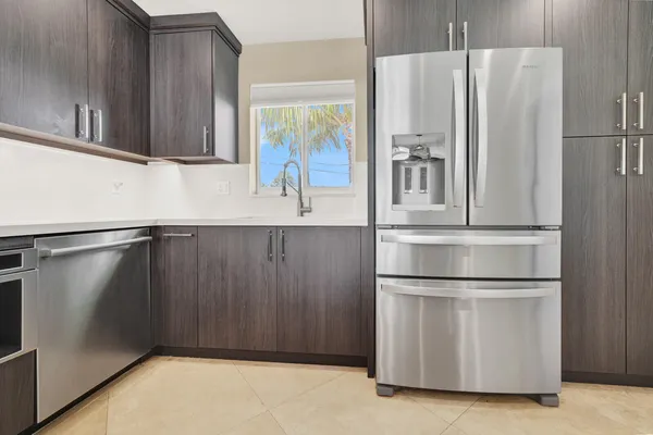 a kitchen with stainless steel appliances granite countertop a refrigerator and a sink
