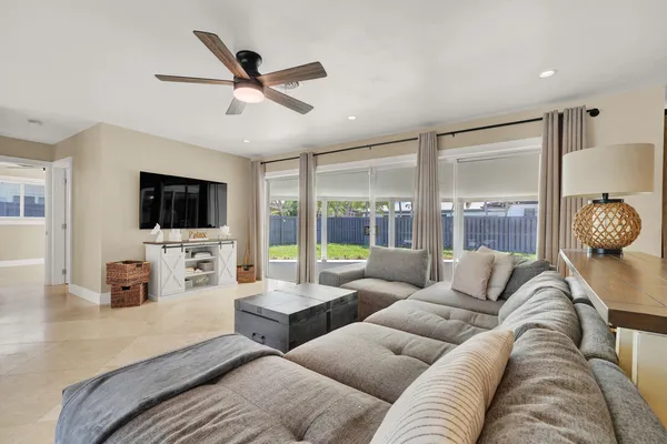 a living room with furniture a flat screen tv and a large window