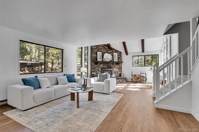 a living room with furniture flat screen tv and a large window