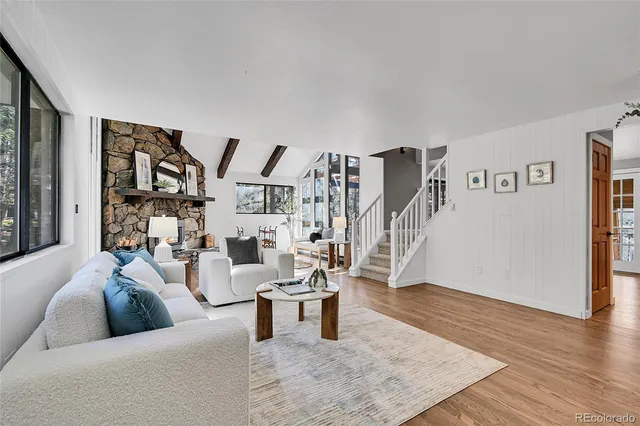a living room with furniture flat screen tv and a large window