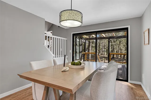 a dining room with furniture a chandelier and wooden floor
