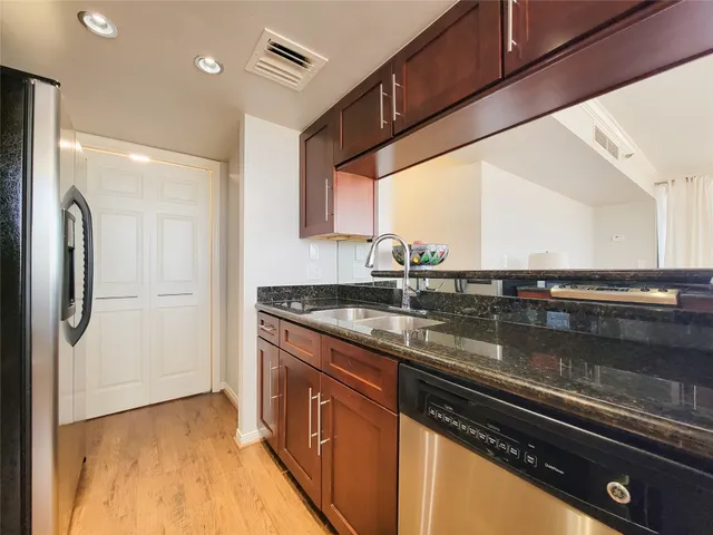 a kitchen with stainless steel appliances granite countertop a sink and a stove