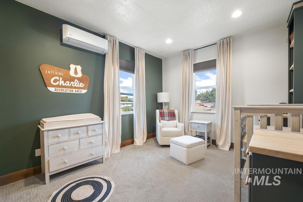 417 East E Street Moscow, ID 83843 - Photo 19 of 29 Bedroom with light carpet, a textured ceiling, a wall mounted AC, and recessed lighting