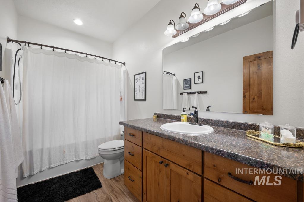 417 East E Street Moscow, ID 83843 - Photo 24 of 29 Full bathroom featuring shower / bathtub combination with curtain, light wood-type flooring, and vanity