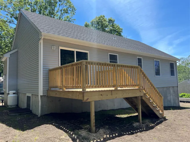 a view of a house with a balcony and car parked
