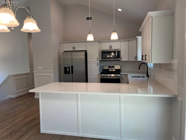 a kitchen with kitchen island a counter top space appliances and cabinets