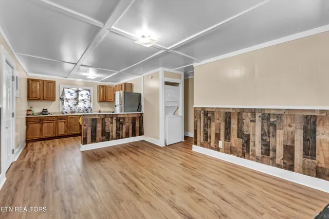 a view of a hallway with wooden floor and a kitchen