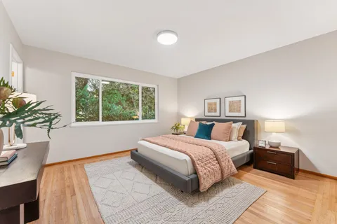 a bedroom with a bed and painting on the wall