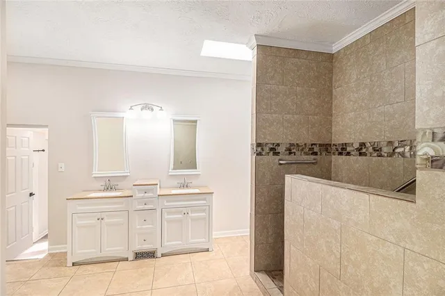 a bathroom with a double vanity sink a mirror and a bathtub