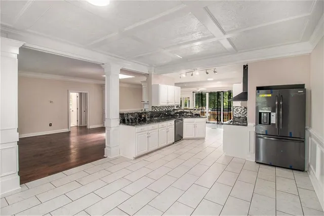 a kitchen with stainless steel appliances kitchen island granite countertop a refrigerator and a stove top oven