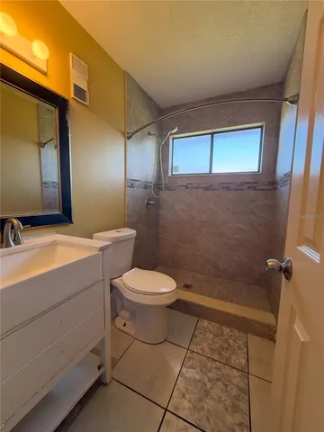 a bathroom with a toilet a sink a mirror and vanity