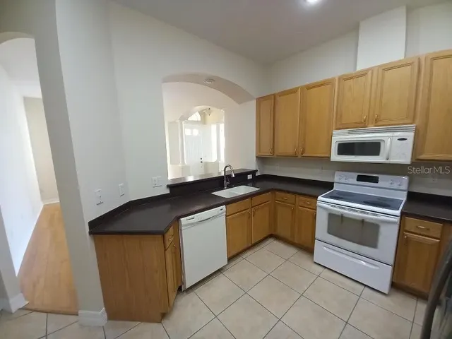 a kitchen with stainless steel appliances granite countertop a stove a sink and a microwave