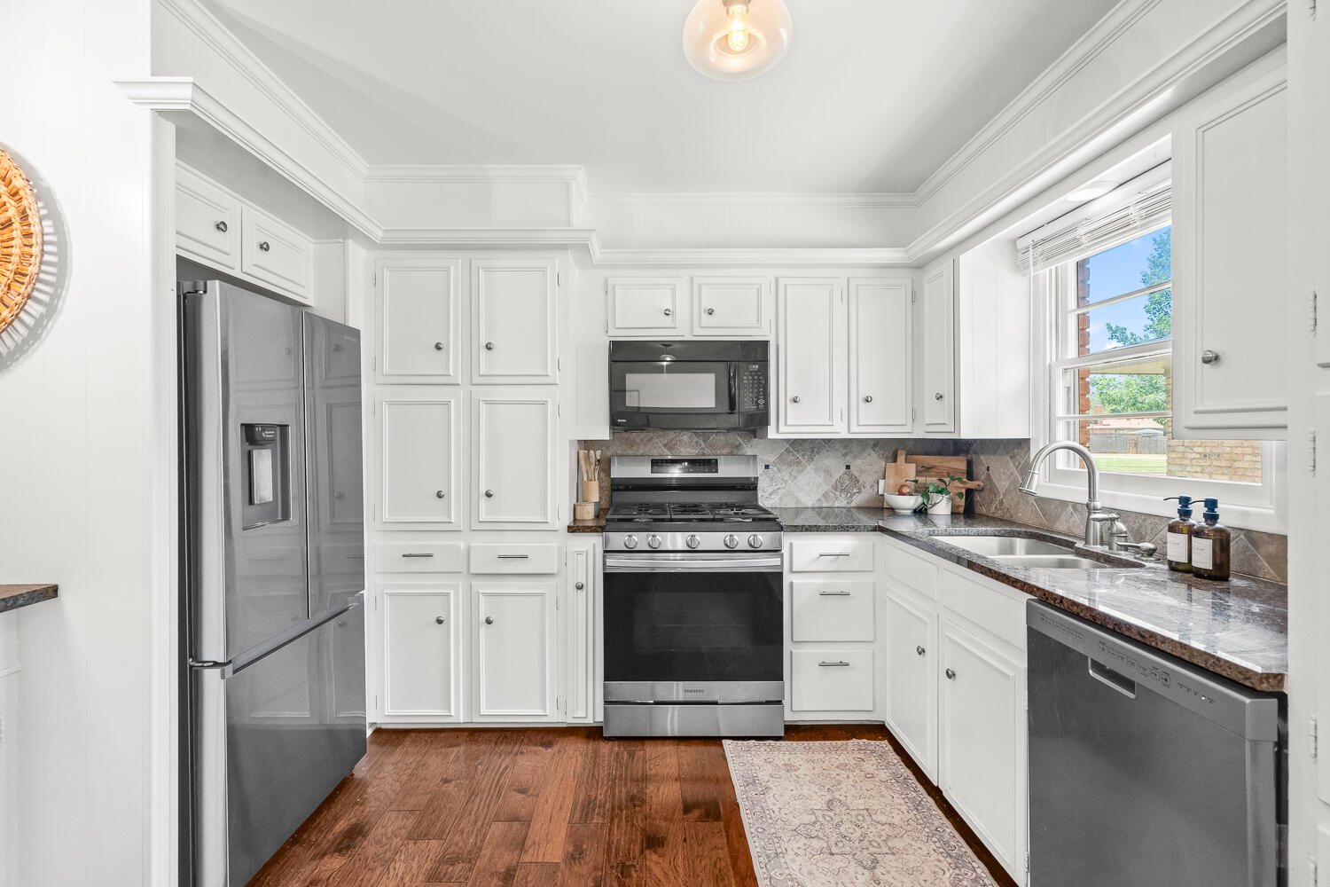 3418 62nd Street Lubbock, TX 79413 - Photo 11 of 45 a kitchen with stainless steel appliances granite countertop a stove a sink and a refrigerator