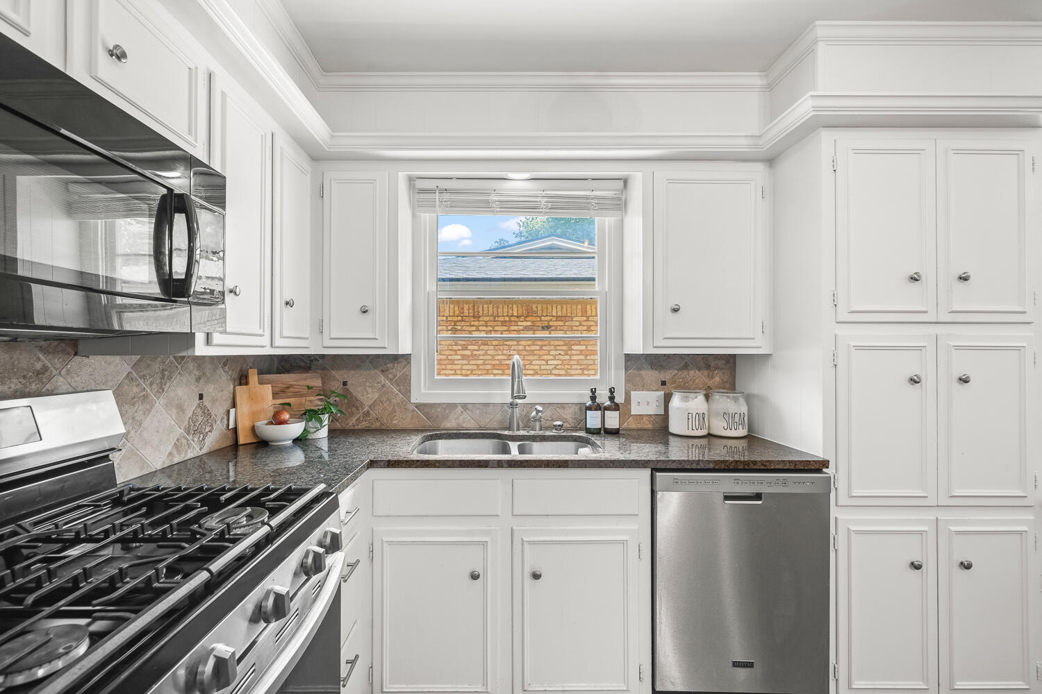 3418 62nd Street Lubbock, TX 79413 - Photo 12 of 45 a kitchen with white cabinets and window