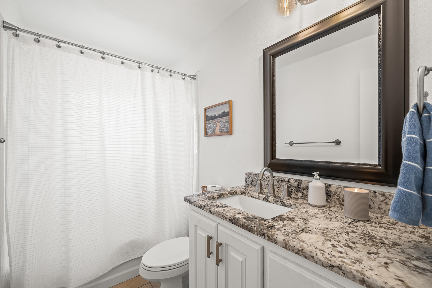 3418 62nd Street Lubbock, TX 79413 - Photo 28 of 45 a bathroom with a granite countertop sink toilet and mirror