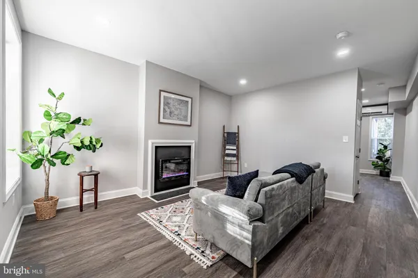 a living room with furniture a potted plant and a fireplace