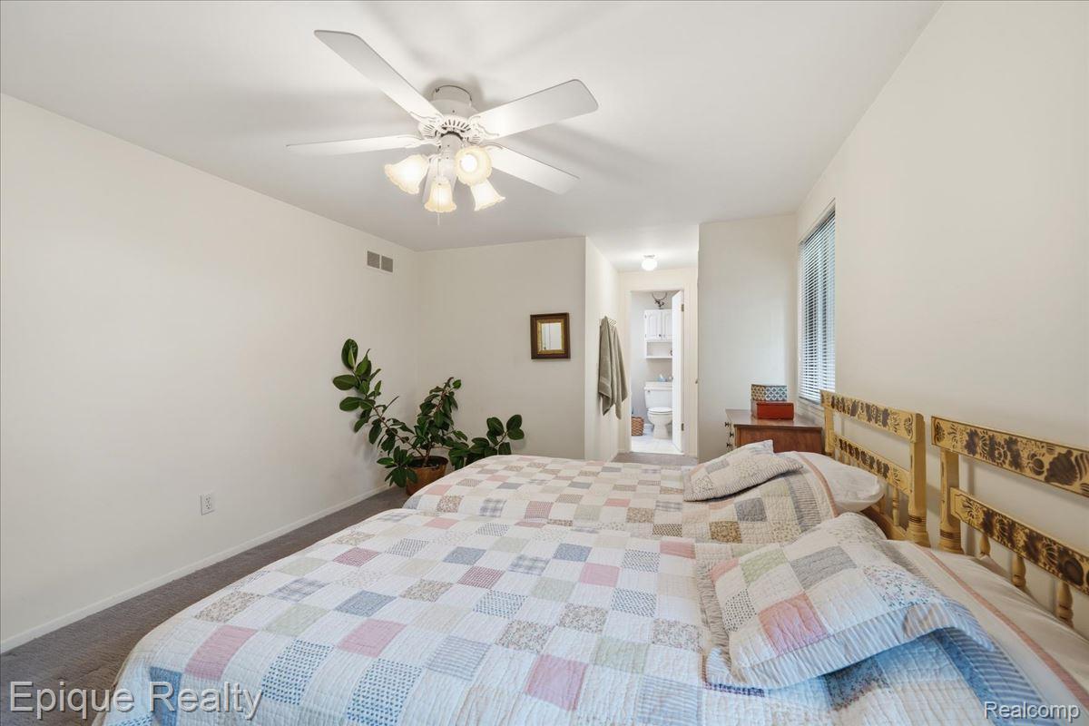 26 Kirks Court Rochester, MI 48309 - Photo 19 of 44 Bedroom featuring carpeting, a ceiling fan with integrated lighting, and a doorway to a bathroom with a visible toilet and white shelving