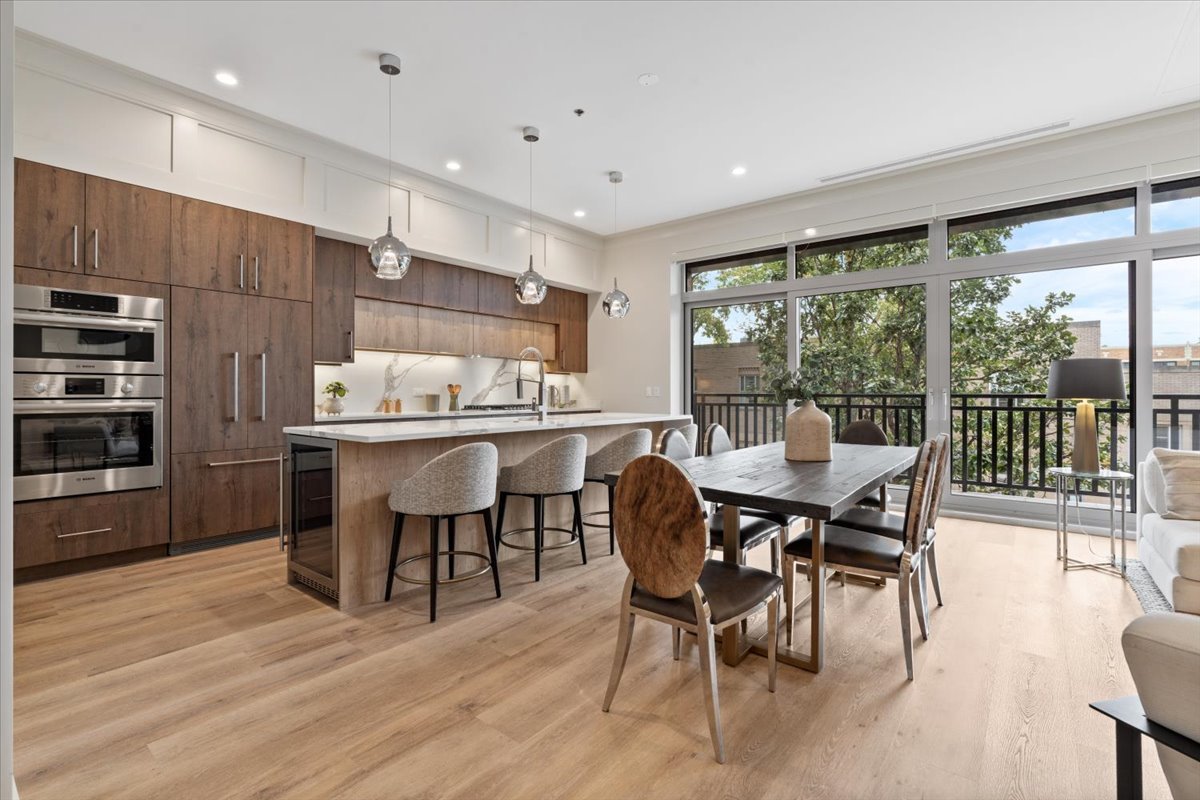 3951 North Wayne Avenue, Unit 304 Chicago, IL 60613 - Photo 13 of 20 a dining hall with stainless steel appliances kitchen island granite countertop a dining table and chairs with wooden floor