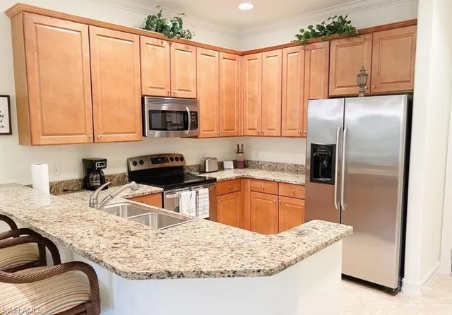 a kitchen with stainless steel appliances granite countertop a sink refrigerator and microwave