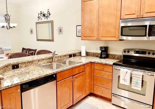 a kitchen with stainless steel appliances granite countertop a sink stove and microwave