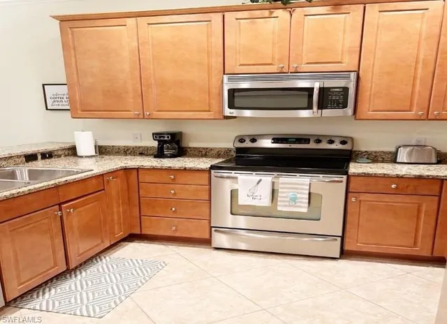 a kitchen with stainless steel appliances granite countertop a stove a sink and a microwave