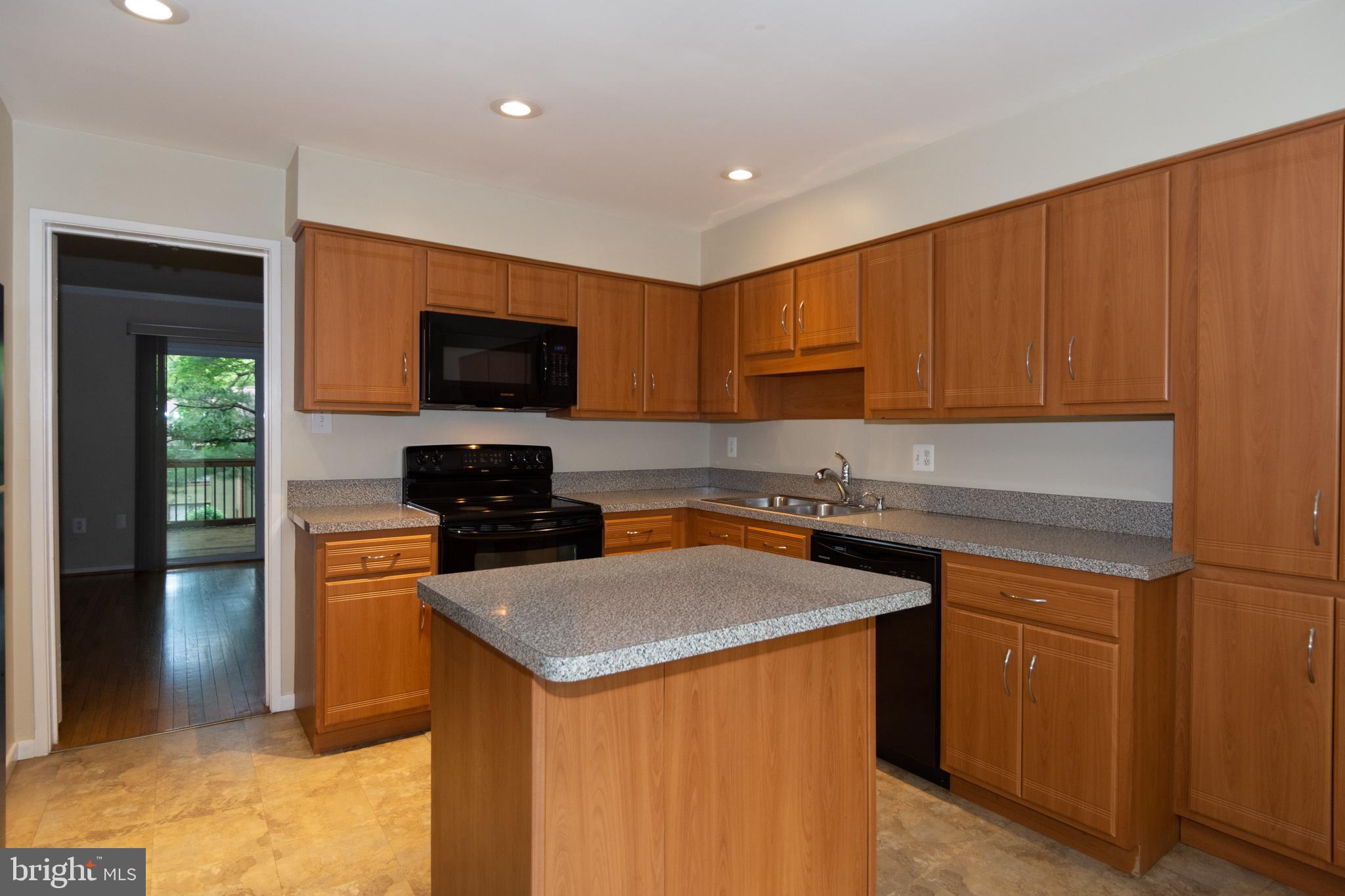 11768 Indian Ridge Road Reston, VA 20191 - Photo 25 of 57 a kitchen with stainless steel appliances granite countertop a stove top oven a sink dishwasher and a refrigerator with wooden cabinets