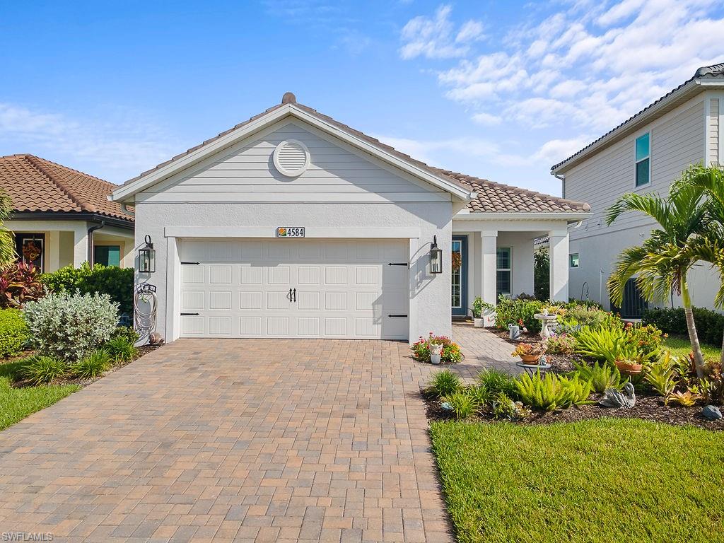 4584 Centaurus Circle Naples, FL 34120 - Photo 1 of 40 Mediterranean / spanish-style house with decorative driveway, a garage, stucco siding, a tiled roof, and a porch