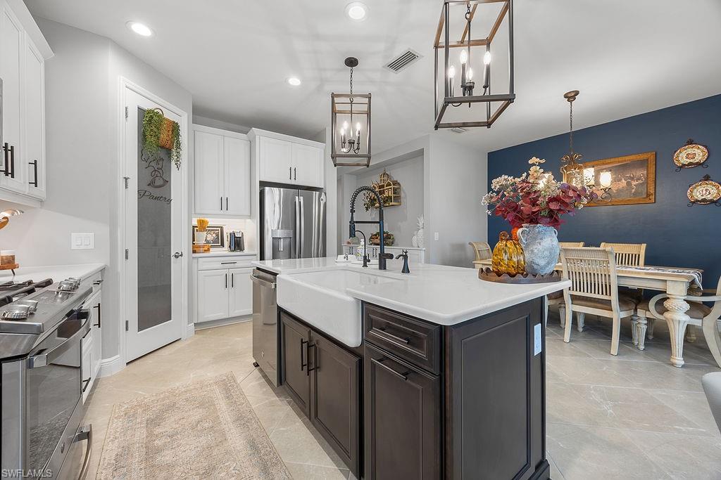 4584 Centaurus Circle Naples, FL 34120 - Photo 17 of 40 Kitchen featuring white cabinets, appliances with stainless steel finishes, hanging light fixtures, and recessed lighting